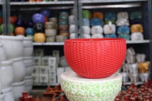 Red round hanging plastic planter with chain for balcony plants
